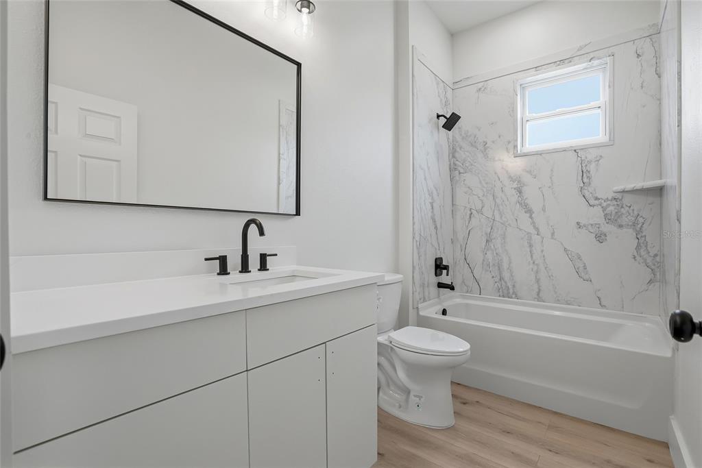 11256 Salters Street Spring Hill, FL 34609 - Photo 26 of 46 a bathroom with a sink a toilet and a tub