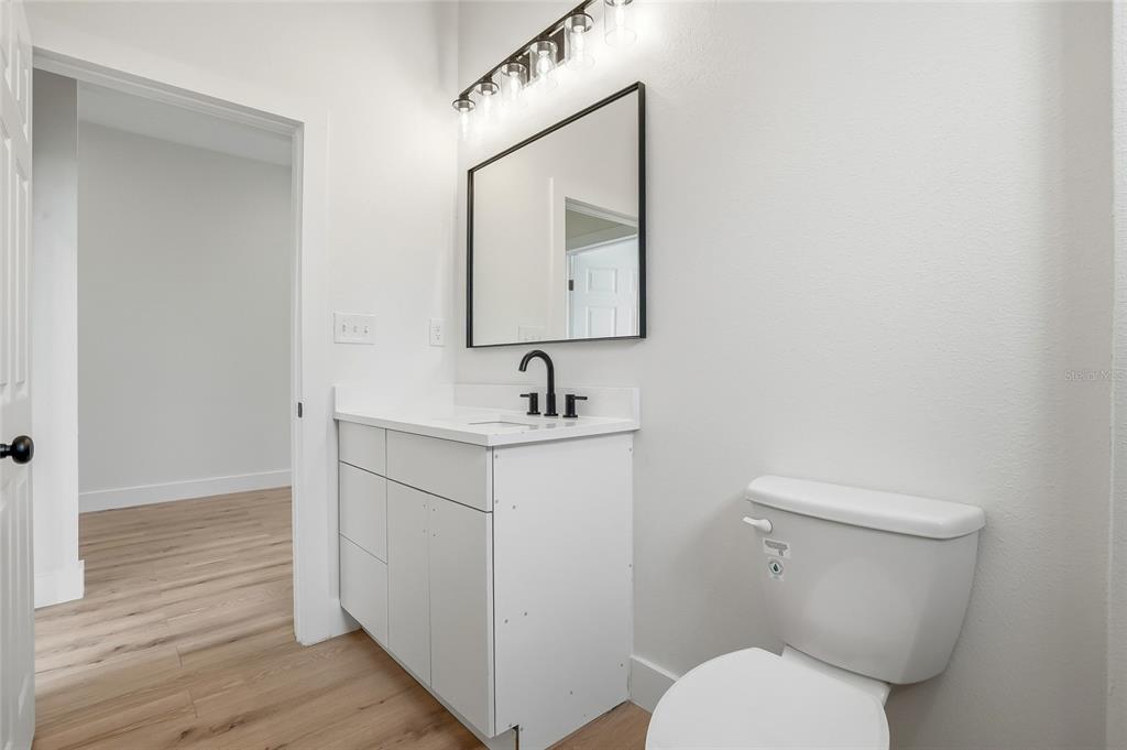 11256 Salters Street Spring Hill, FL 34609 - Photo 27 of 46 a bathroom with a toilet a sink and mirror