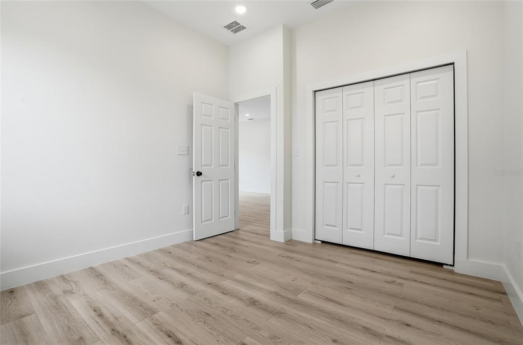 11256 Salters Street Spring Hill, FL 34609 - Photo 31 of 46 a view of an empty room with wooden floor