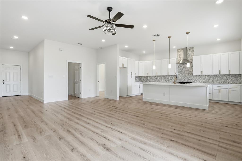 11256 Salters Street Spring Hill, FL 34609 - Photo 4 of 46 an open kitchen with kitchen island white cabinets and stainless steel appliances