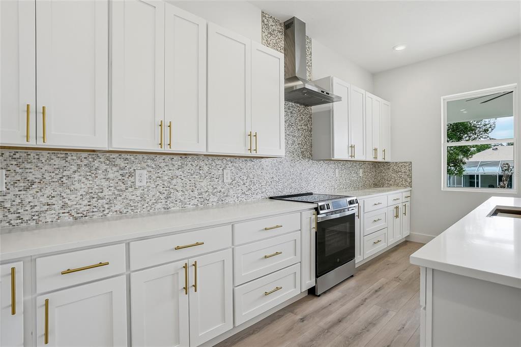 11256 Salters Street Spring Hill, FL 34609 - Photo 8 of 46 a kitchen with granite countertop white cabinets and white appliances