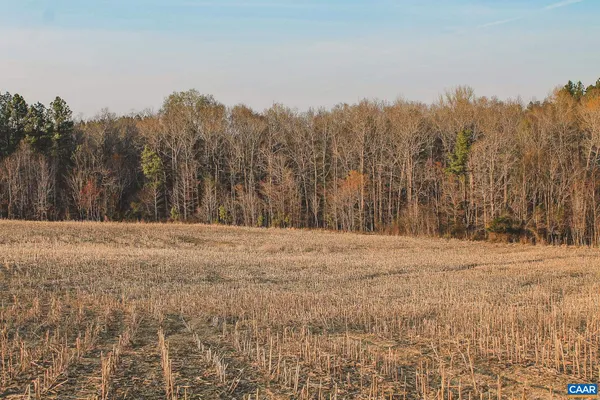 a view of lake with outdoor seating and trees in the background
