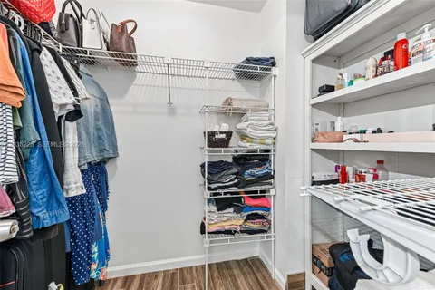 a view of walk in closet with clothes and shoes