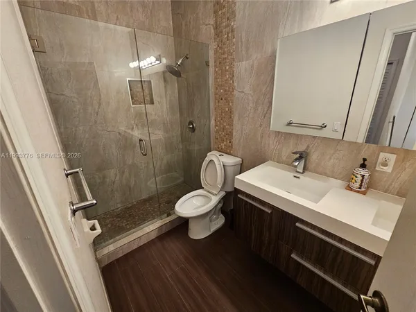 a bathroom with a sink a toilet and shower
