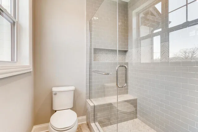 a bathroom with a toilet and a shower