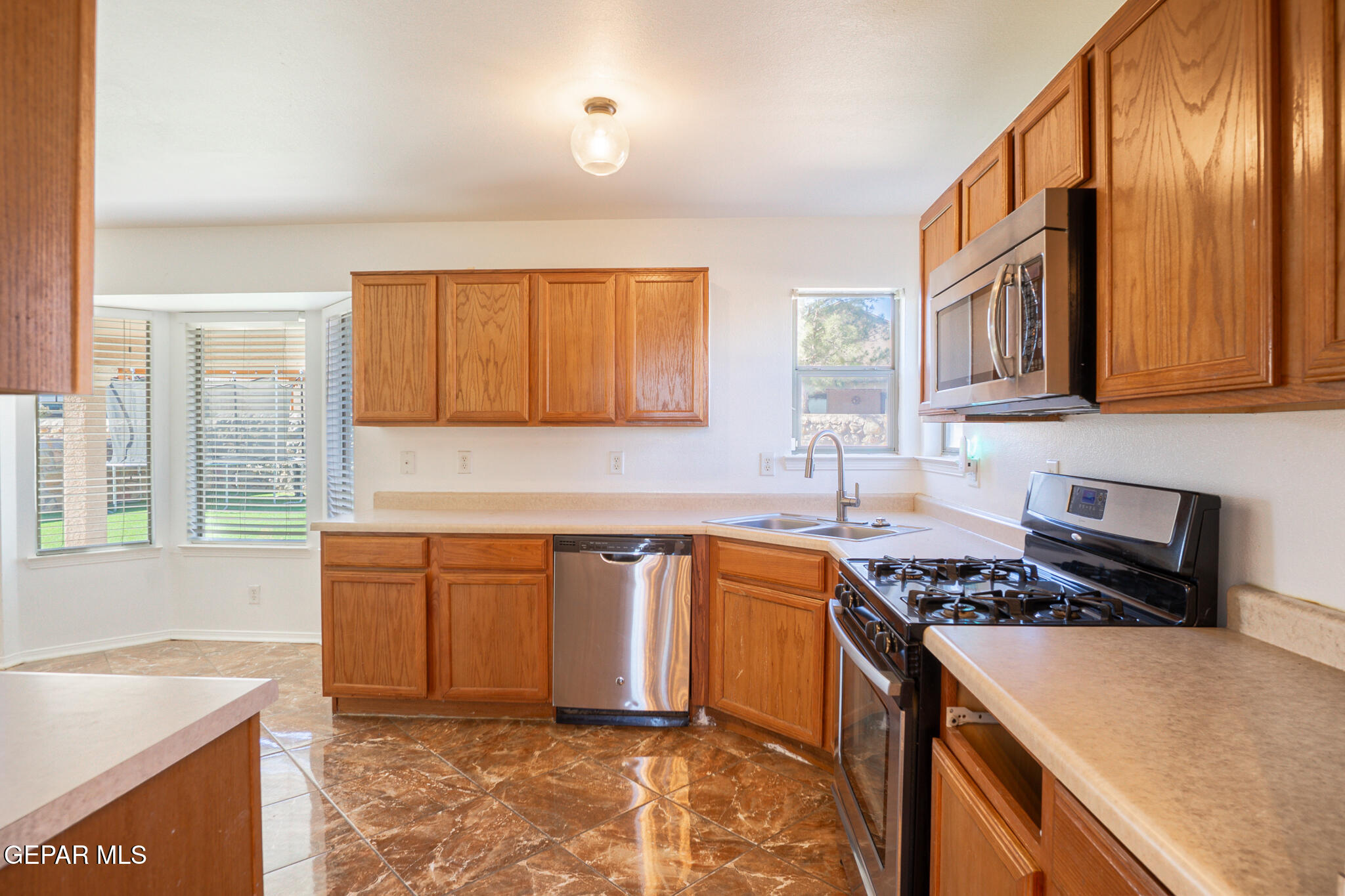 1497 Dunlin Place El Paso, TX 79928 - Photo 7 of 38 a kitchen with stainless steel appliances granite countertop a stove a sink and a microwave