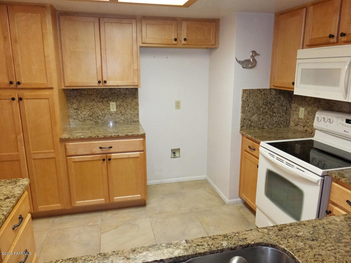 11950 Rawhide Ridge Dewey, AZ 86327 - Photo 10 of 37 a kitchen with granite countertop a sink a stove and cabinets