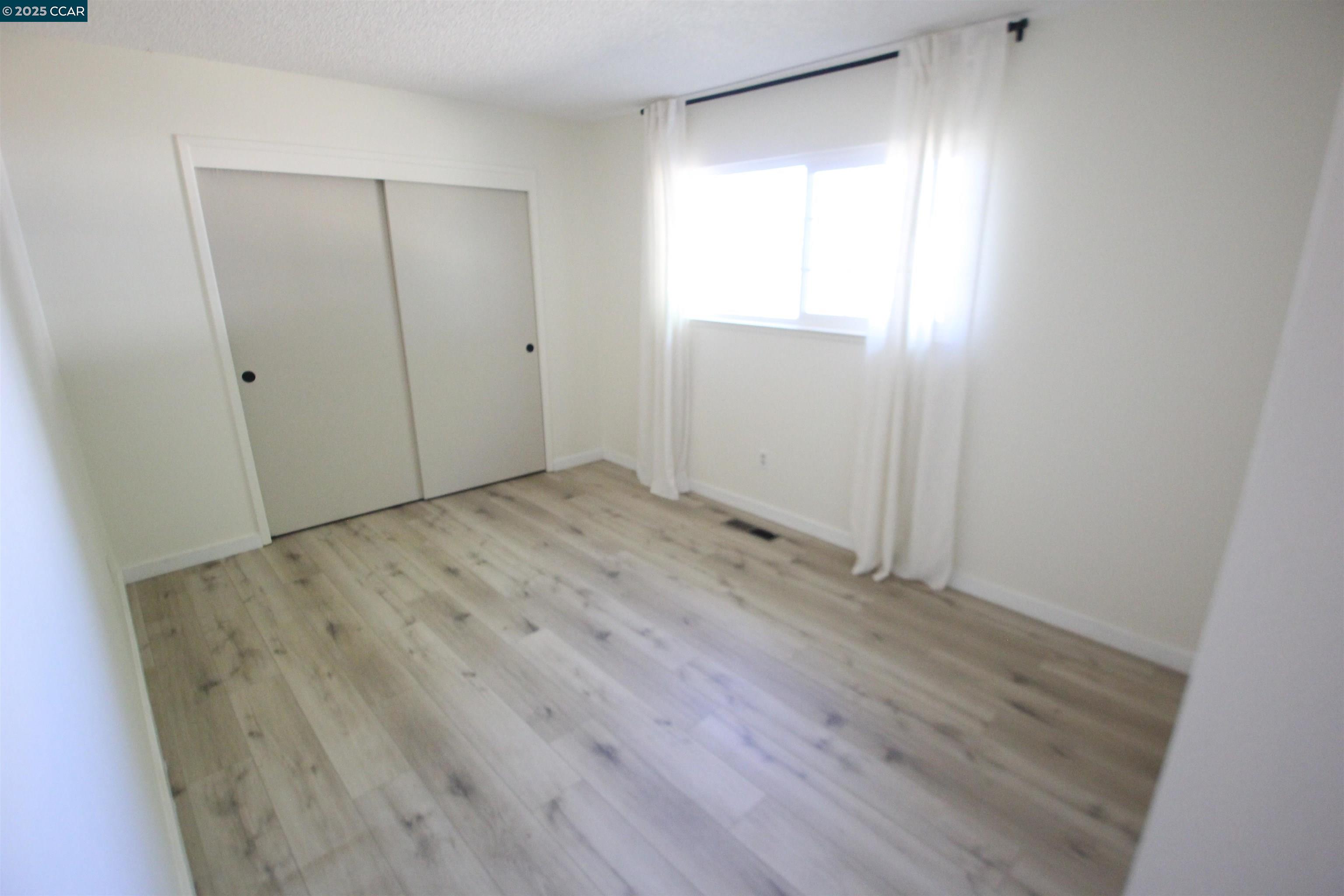 10 School Street Isleton, CA 95641 - Photo 11 of 23 a view of an empty room with wooden floor and closet