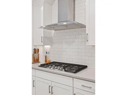 a stove top oven sitting inside of a kitchen