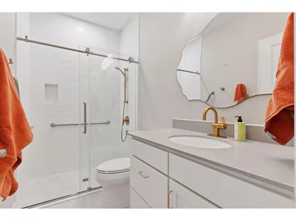 a bathroom with a granite countertop sink mirror toilet and shower