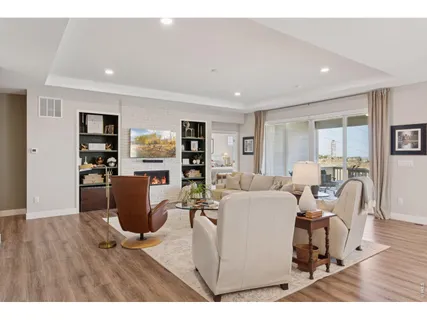 a living room with furniture a dining table and a wooden floor
