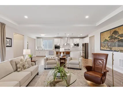 a living room with furniture white walls and kitchen view