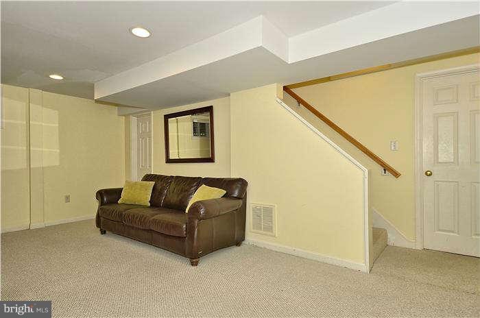 9503 St Andrews Way Silver Spring, MD 20901 - Photo 24 of 30 a living room with white walls and a couch