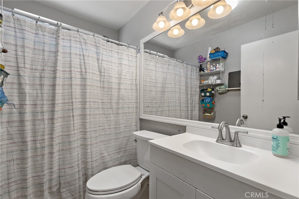 43545 Corte Logrono Temecula, CA 92592 - Photo 28 of 49 a bathroom with a sink a toilet and shower curtain