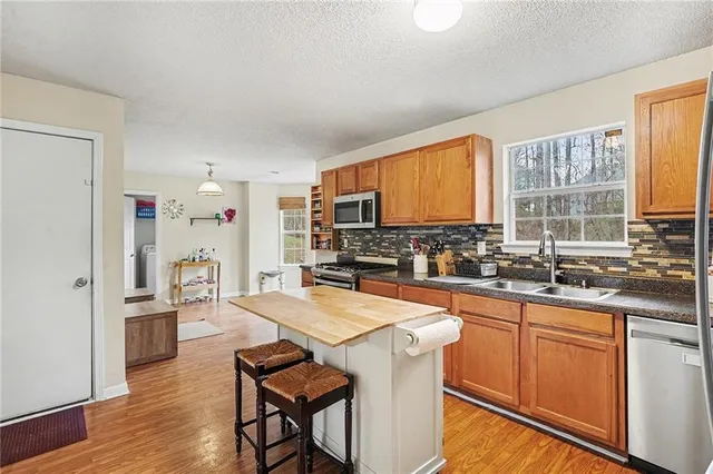 a kitchen with granite countertop a sink appliances cabinets and counter space