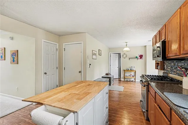 a kitchen with stainless steel appliances granite countertop a sink stove and refrigerator