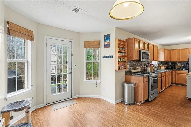 a kitchen with stainless steel appliances granite countertop a stove a sink and a refrigerator