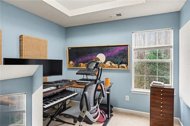 a view of a workspace with furniture and a window