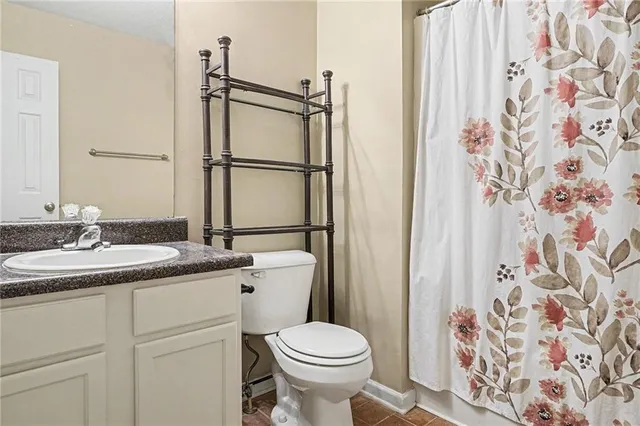 a bathroom with a granite countertop sink toilet and shower