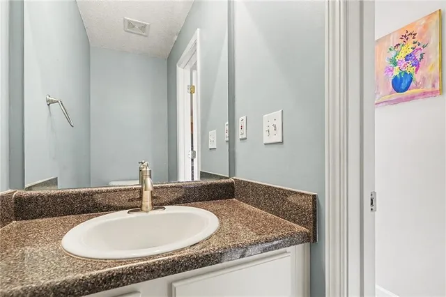 a bathroom with a granite countertop sink and a mirror