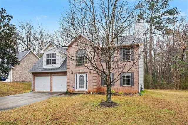 a tree in front of a white house