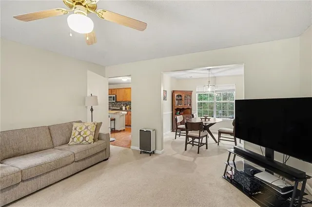 a living room with furniture flat screen tv and a large window