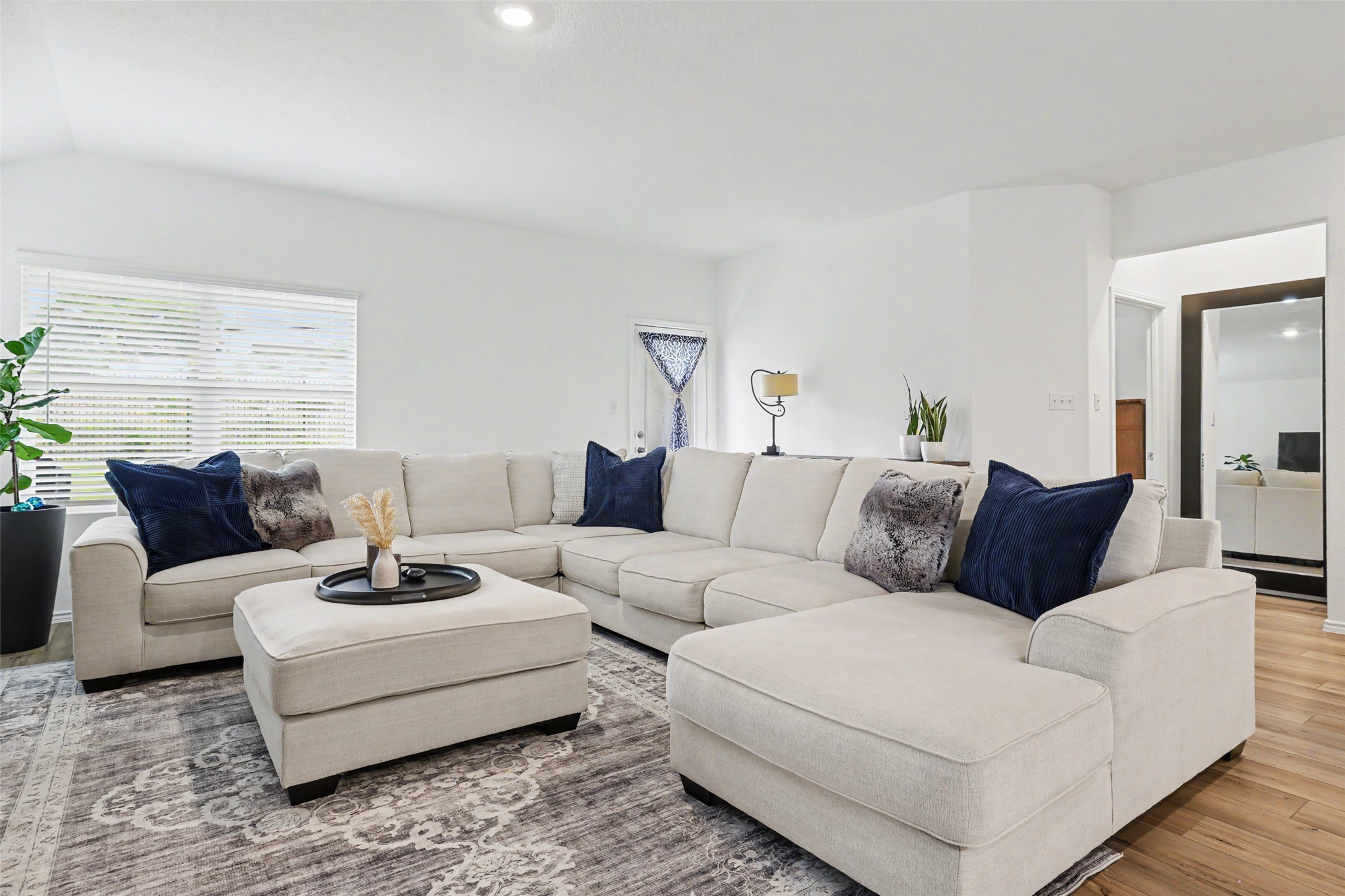 2333 Four Waters Loop Georgetown, TX 78628 - Photo 9 of 35 Spacious living area featuring high vaulted ceilings, recessed lighting, wood-finish flooring, and a large window with horizontal blinds