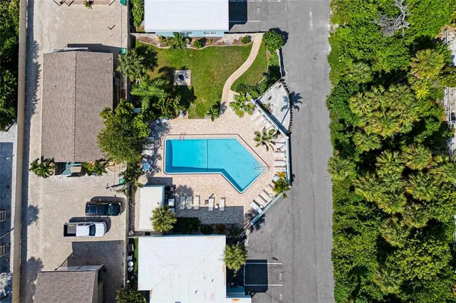 an aerial view of a white house with wooden fence