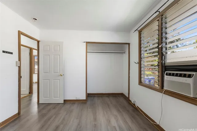 a view of a hallway with wooden floor and closet
