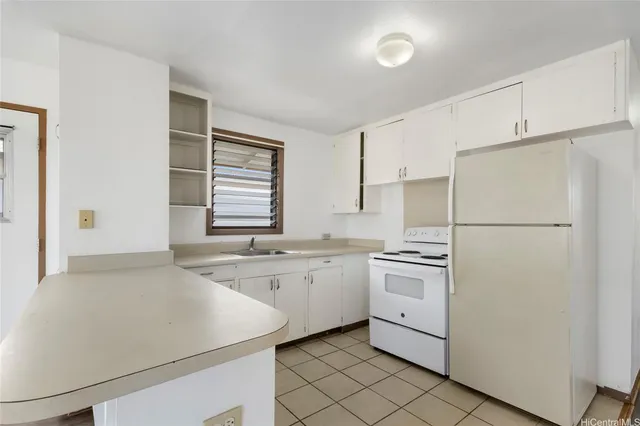 a kitchen with white cabinets and white appliances