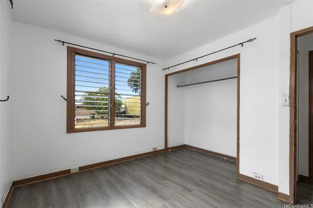 an empty room with wooden floor and a window