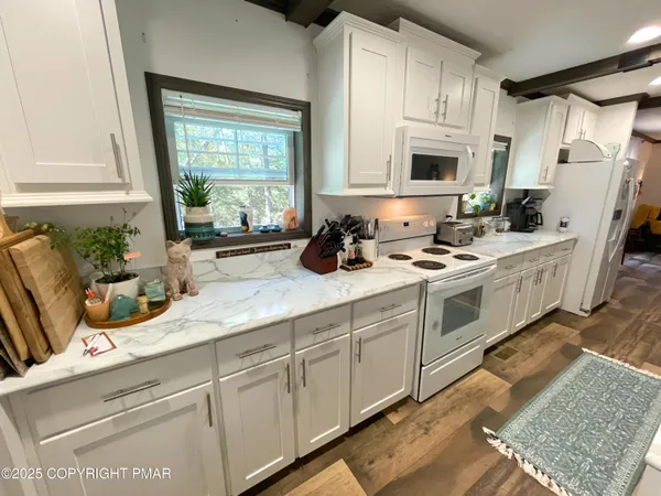 a kitchen with stainless steel appliances granite countertop a sink a stove a refrigerator a counter space and cabinets