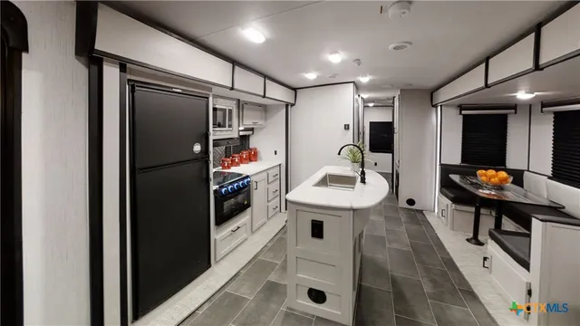a kitchen with stainless steel appliances granite countertop a refrigerator and a sink