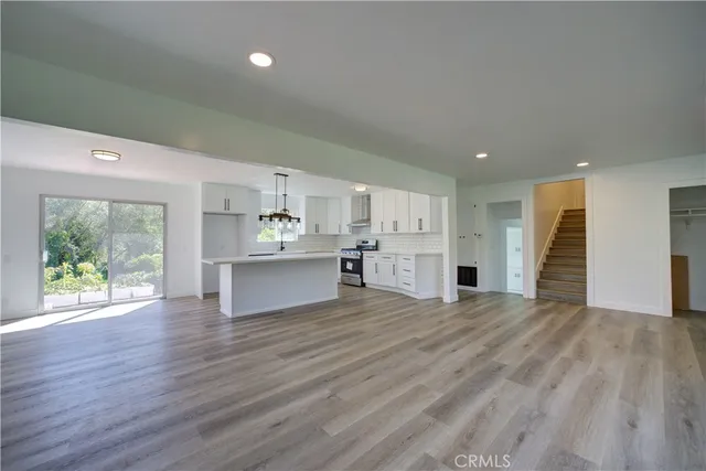 a view of kitchen with kitchen island wooden cabinets and refrigerator