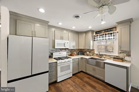 a kitchen with white cabinets and white appliances