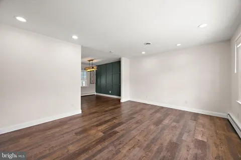 an empty room with wooden floor and natural light