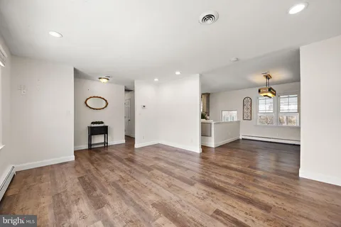 a view of empty room with wooden floor and fireplace