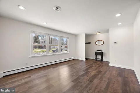an empty room with wooden floor and a window