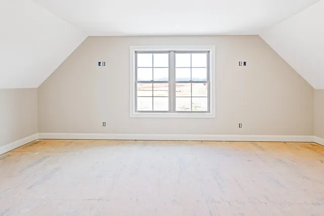 an empty room with a window and ceiling fan