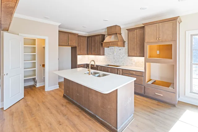 a kitchen with stainless steel appliances granite countertop a stove a sink and a microwave oven with cabinets