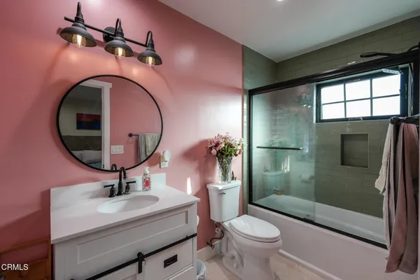 a bathroom with a sink a toilet and a mirror