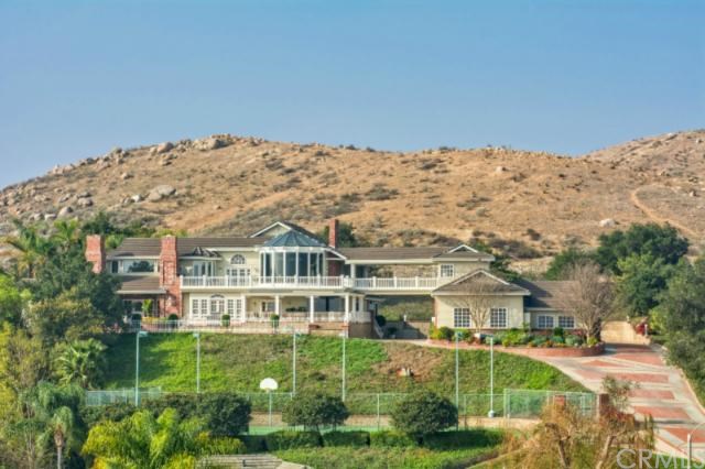 11986 Tilden Place Riverside, CA 92505 - Photo 1 of 1 a view of a white house next to a yard with a fountain and large trees