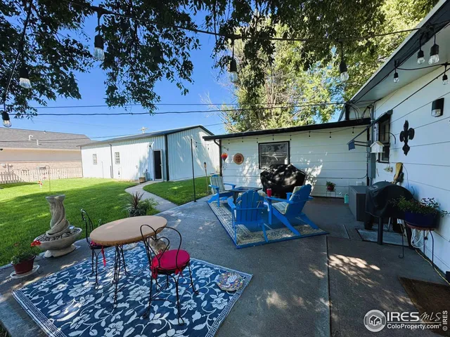 a view of a house with a big yard and large trees