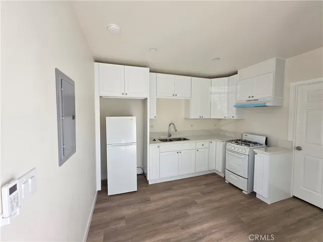 a kitchen with white cabinets and white appliances
