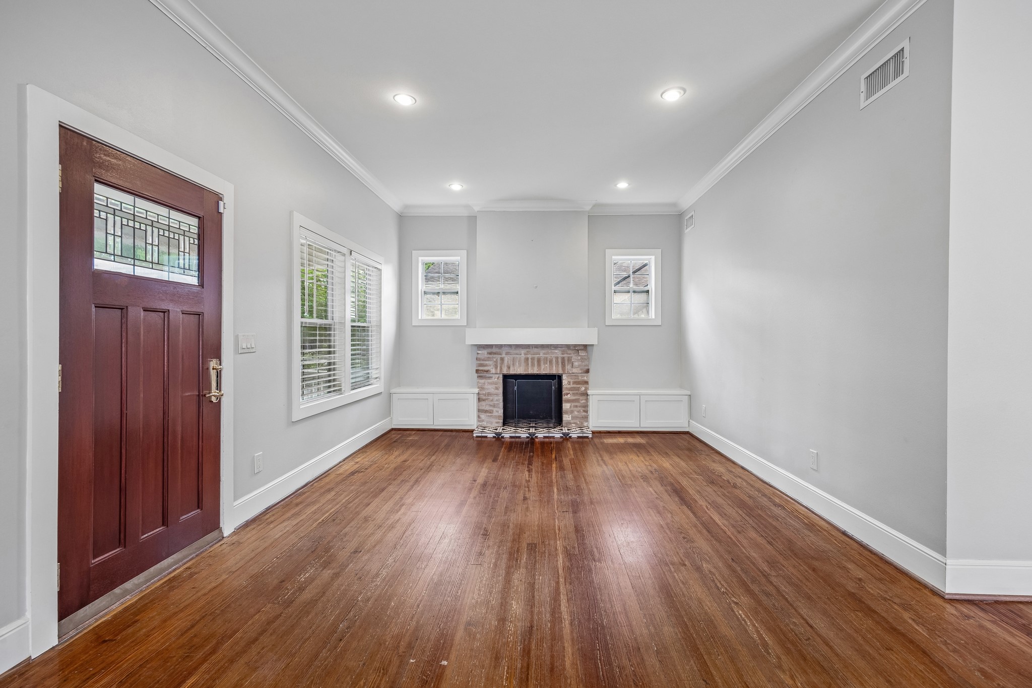 4412 Rusk Street Houston, TX 77023 - Photo 5 of 44 Charming fireplace with brick surround is flanked by two windows, crown molding & recessed lighting.
