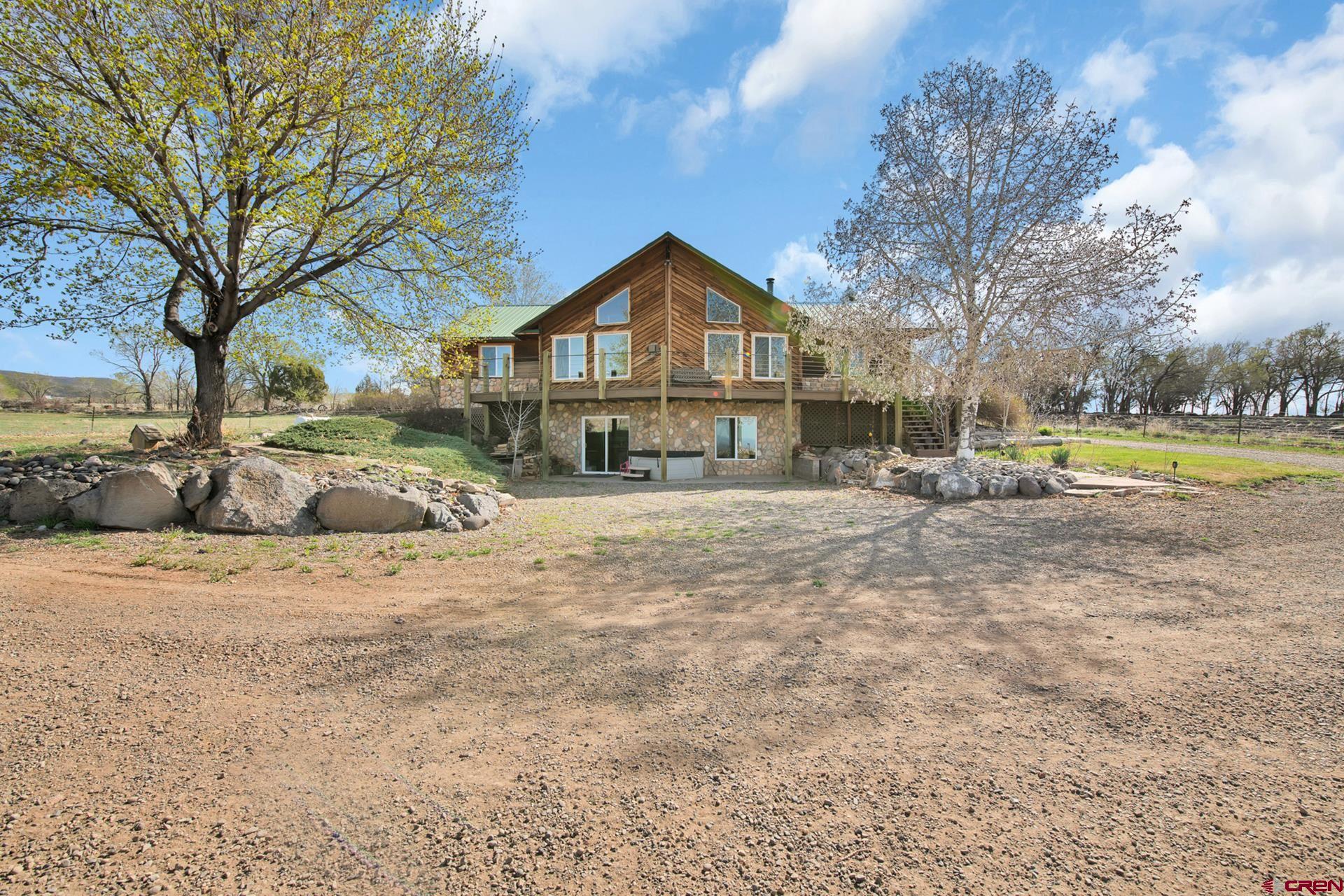 19122 2325th Road Cedaredge, CO 81413 - Photo 2 of 45 a front view of a house with a yard and trees