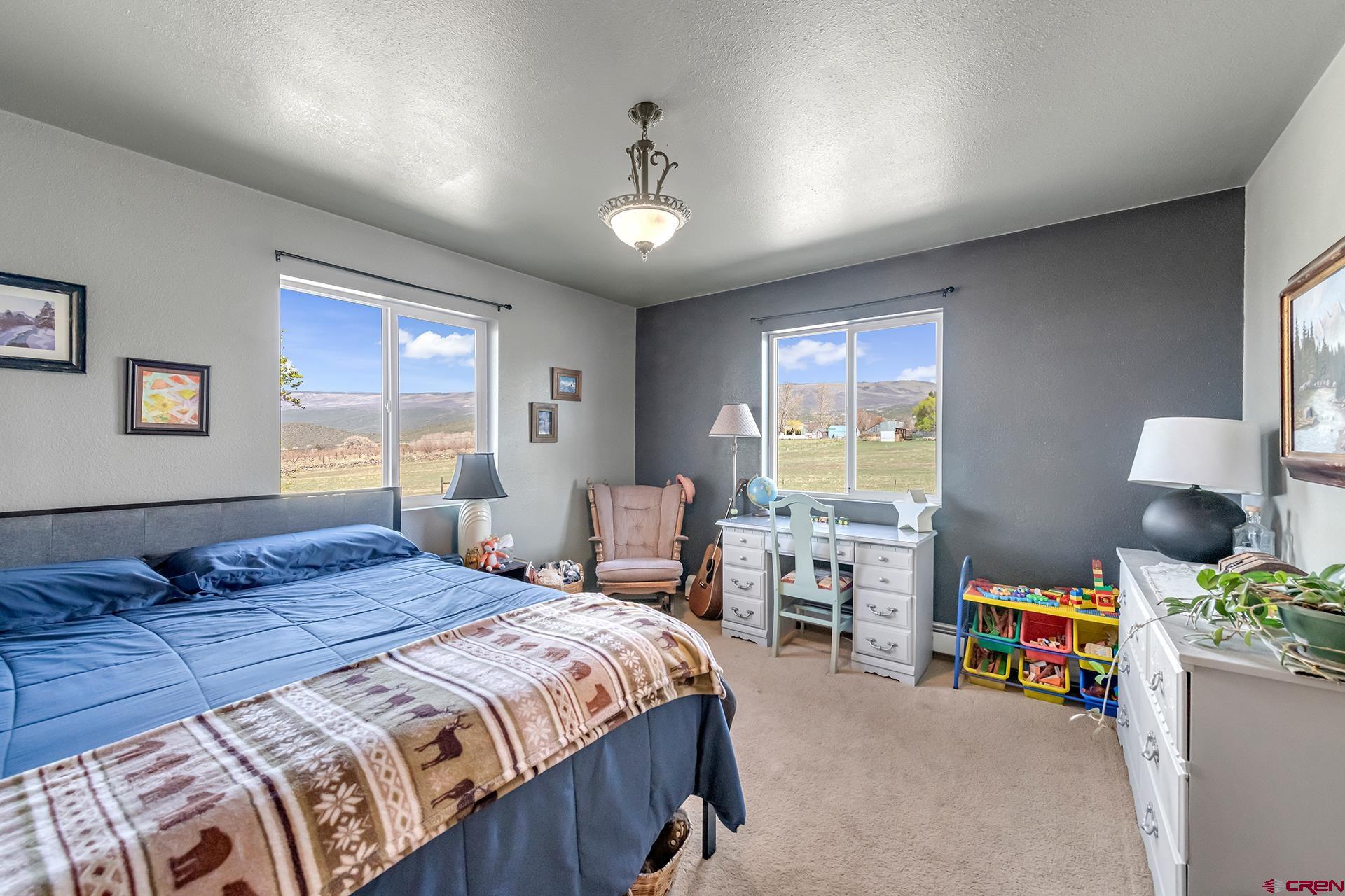 19122 2325th Road Cedaredge, CO 81413 - Photo 27 of 45 a bedroom with a bed and a chandelier