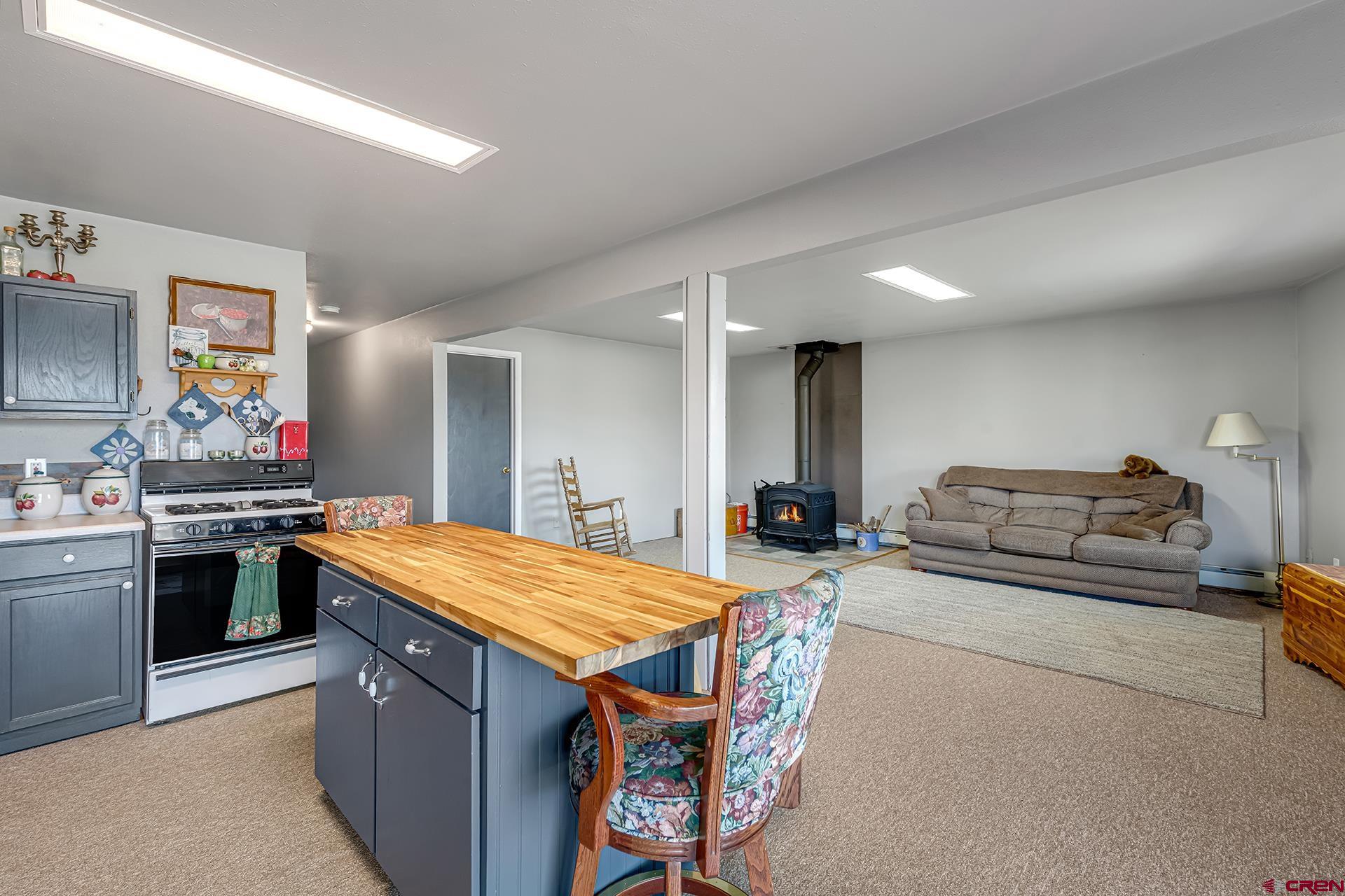 19122 2325th Road Cedaredge, CO 81413 - Photo 29 of 45 a kitchen with stainless steel appliances granite countertop a stove a sink dishwasher and a refrigerator with wooden floor