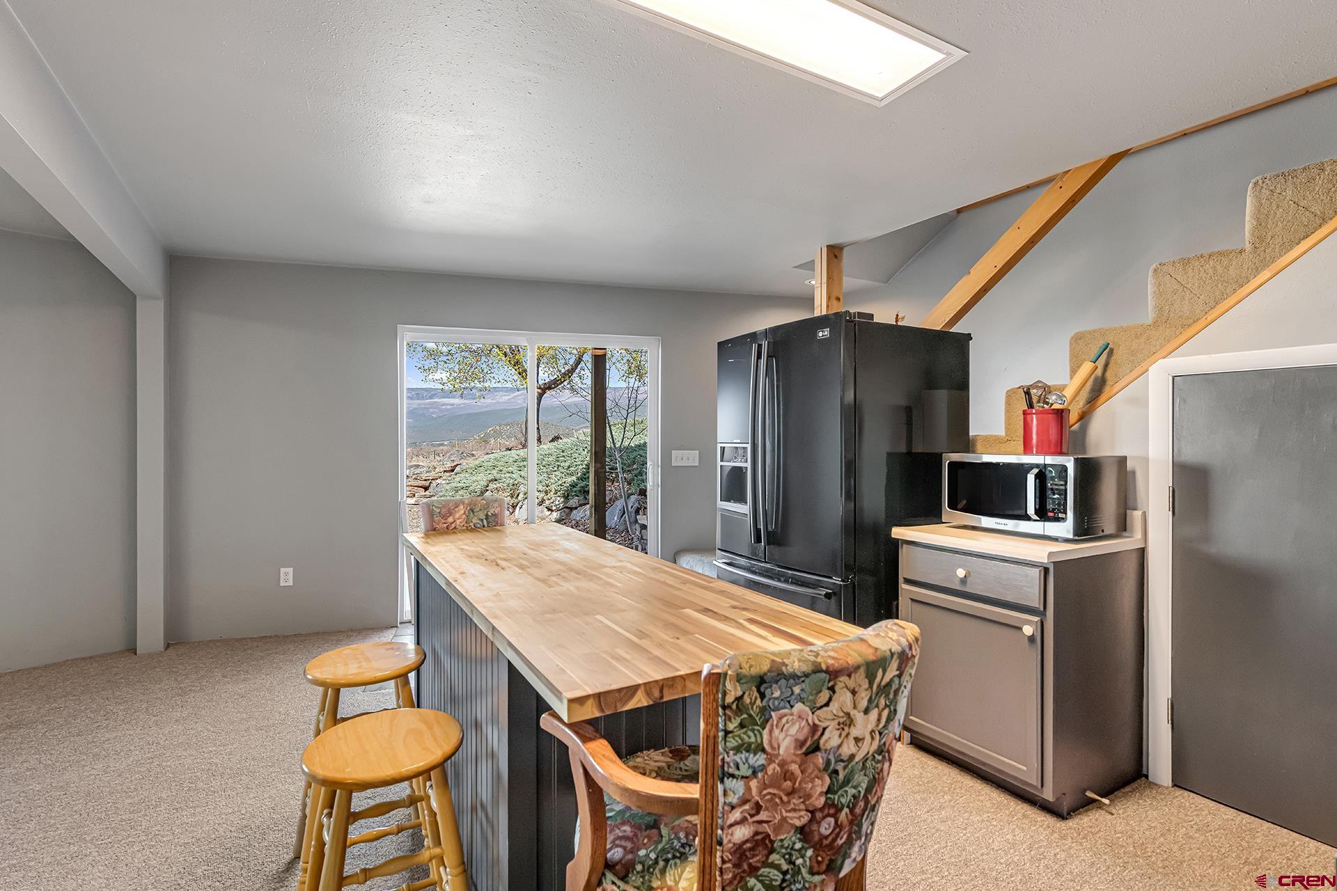 19122 2325th Road Cedaredge, CO 81413 - Photo 30 of 45 a kitchen with stainless steel appliances a refrigerator a sink a stove a dining table and chairs