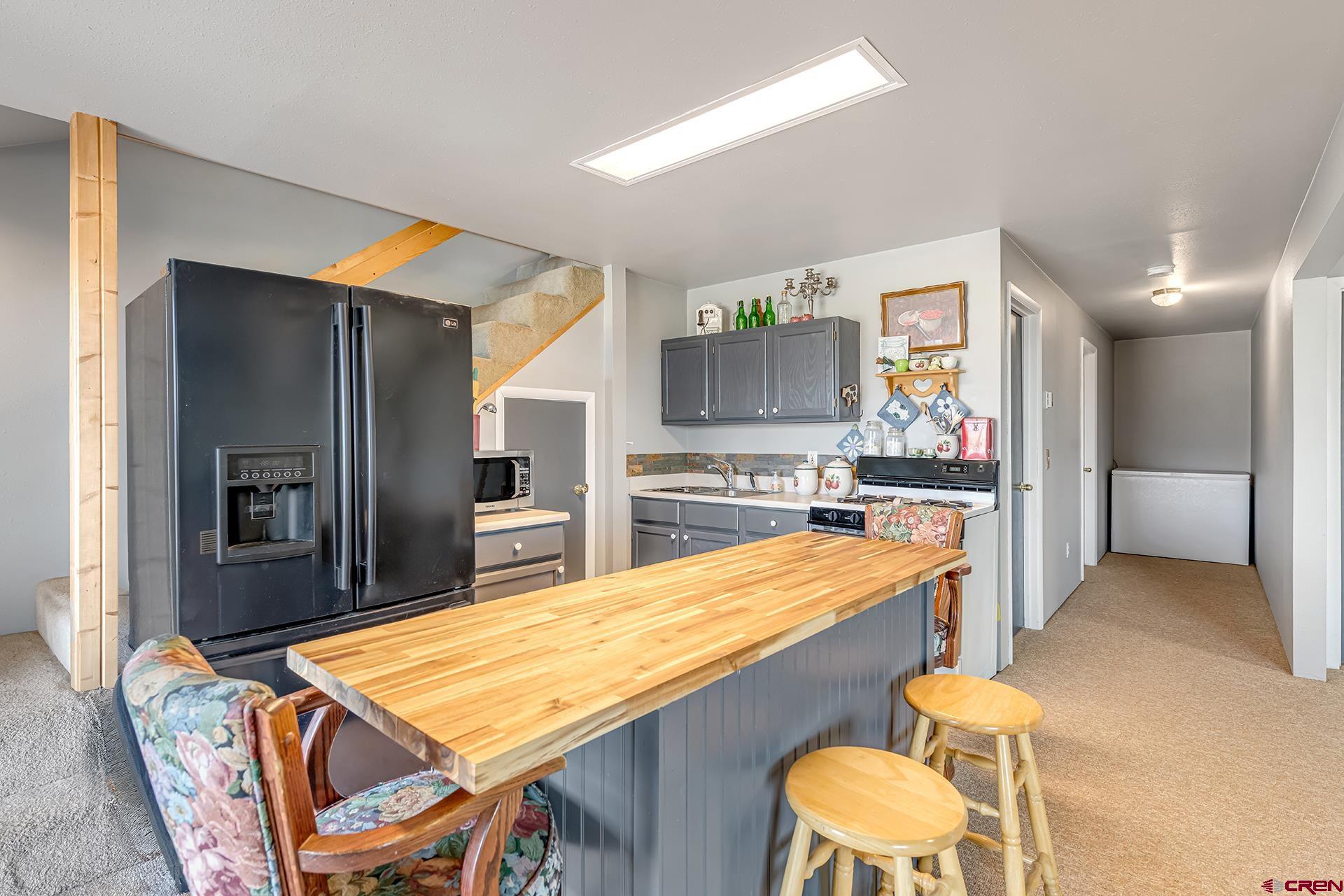 19122 2325th Road Cedaredge, CO 81413 - Photo 31 of 45 a kitchen with stainless steel appliances kitchen island granite countertop dining table chairs and granite counter tops
